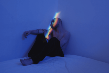 Sad man sitting in a dark room.